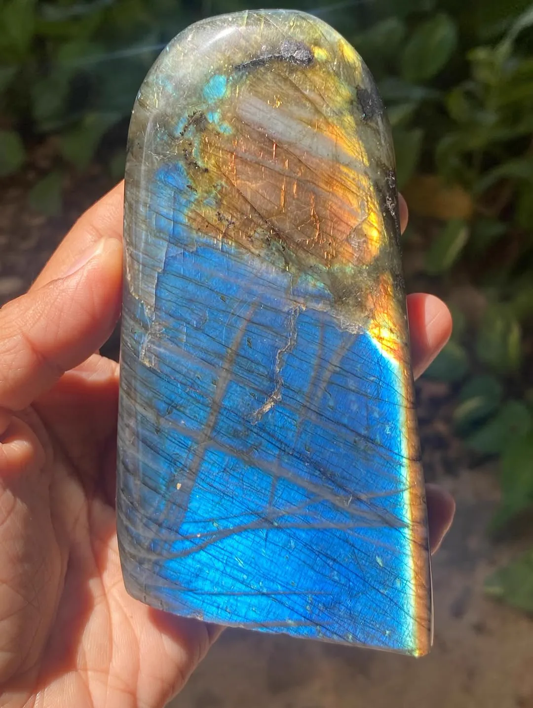 ลาบราโดไรต์แบบใกล้ เห็นประกายสีน้ำเงินทองและพื้นผิวของหินในแสงธรรมชาติ